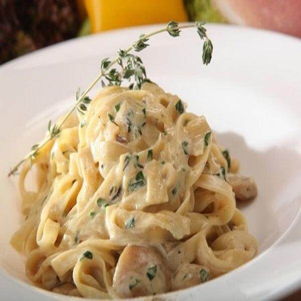 Delicious dish of creamy fettuccine pasta with herbs, perfect for pairing with Paté Artigianale di Funghi Porcini.