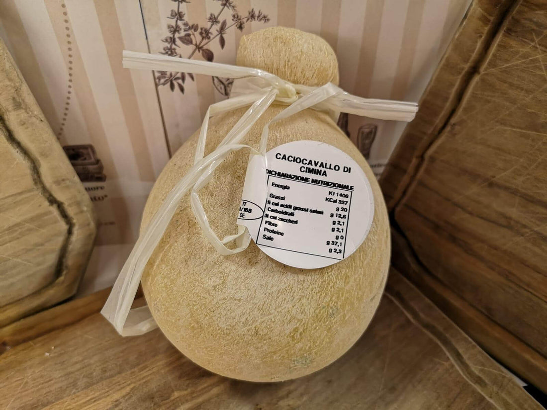 Caciocavallo di Ciminà cheese displayed in traditional packaging with a label.