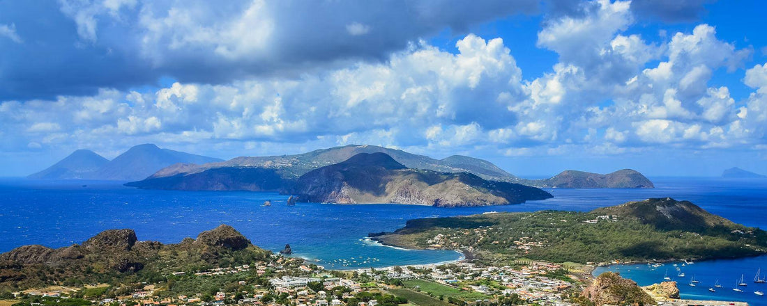 Panorama delle Isole Eolie con mare blu cobalto, coste rocciose vulcaniche e vegetazione mediterranea
