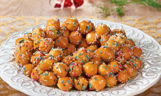 Pignolata dolce di Carnevale alla calabrese con miele a forma di pigna su piatto da portata