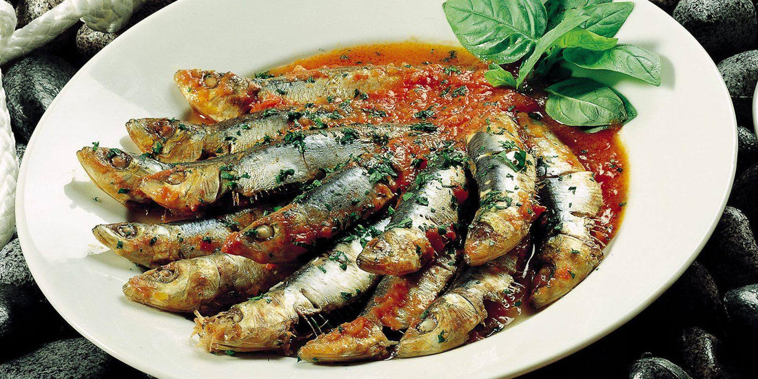 Delicious Zuppa di Pesce with fresh fish garnished with basil on a white plate.
