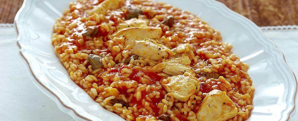 Delicious Risotto alla Sbirraglia served on a white platter, showcasing a flavorful chicken and tomato dish.