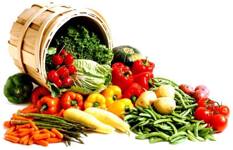 Frutta e Verdura Fresca in un cesto di legno con pomodori, peperoni, zucchine e legumi freschi.