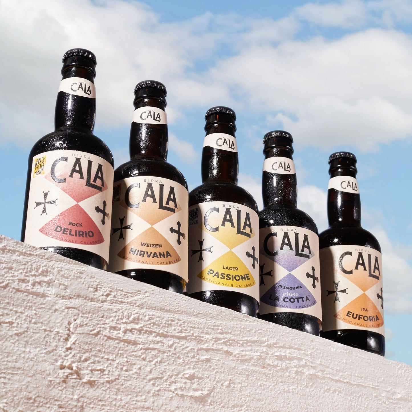 Birra Artigianale Calabrese 33 cl confezione da 6 bottiglie con etichette creative e vista sul cielo.