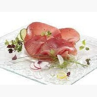 Bresaola di Tonno del Mediterraneo su un piatto elegante, guarnita con erbe fresche e verdure.