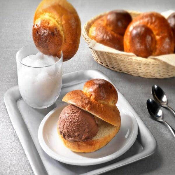 Brioche col Tuppo served with gelato and granita, showcasing traditional Sicilian and Calabrian dessert.