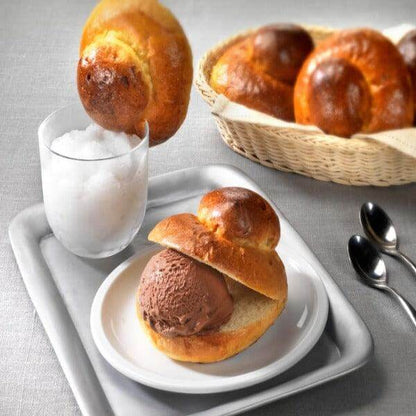 Brioche col Tuppo served with gelato and granita, showcasing traditional Sicilian and Calabrian dessert.