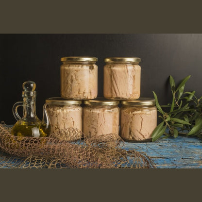 Filetti di Tonno Calabrese in olio d'oliva, barattoli in vetro su tavolo di legno.