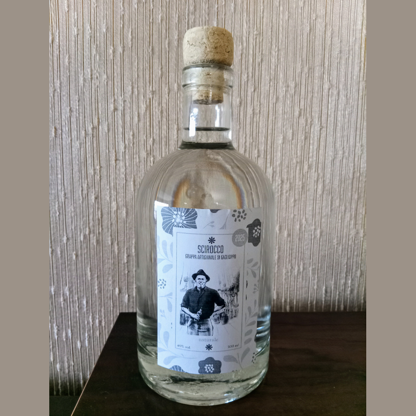 Grappa Artigianale di Gaglioppo in una bottiglia elegante con etichetta artistica.