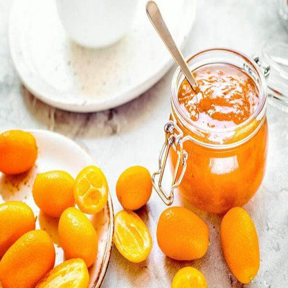 Delicious kumquats and jar of kumquat jam on a marble surface, perfect for decoration and flavor.