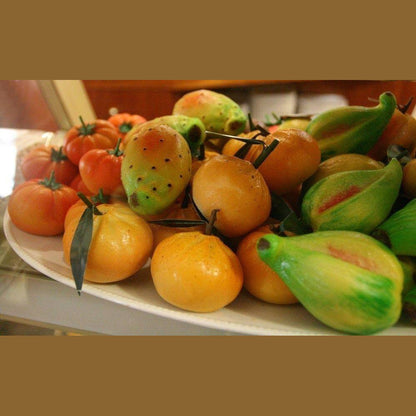 Colorful Sicilian Martorana fruits shaped like tomatoes and pears, made from almonds and sugar.