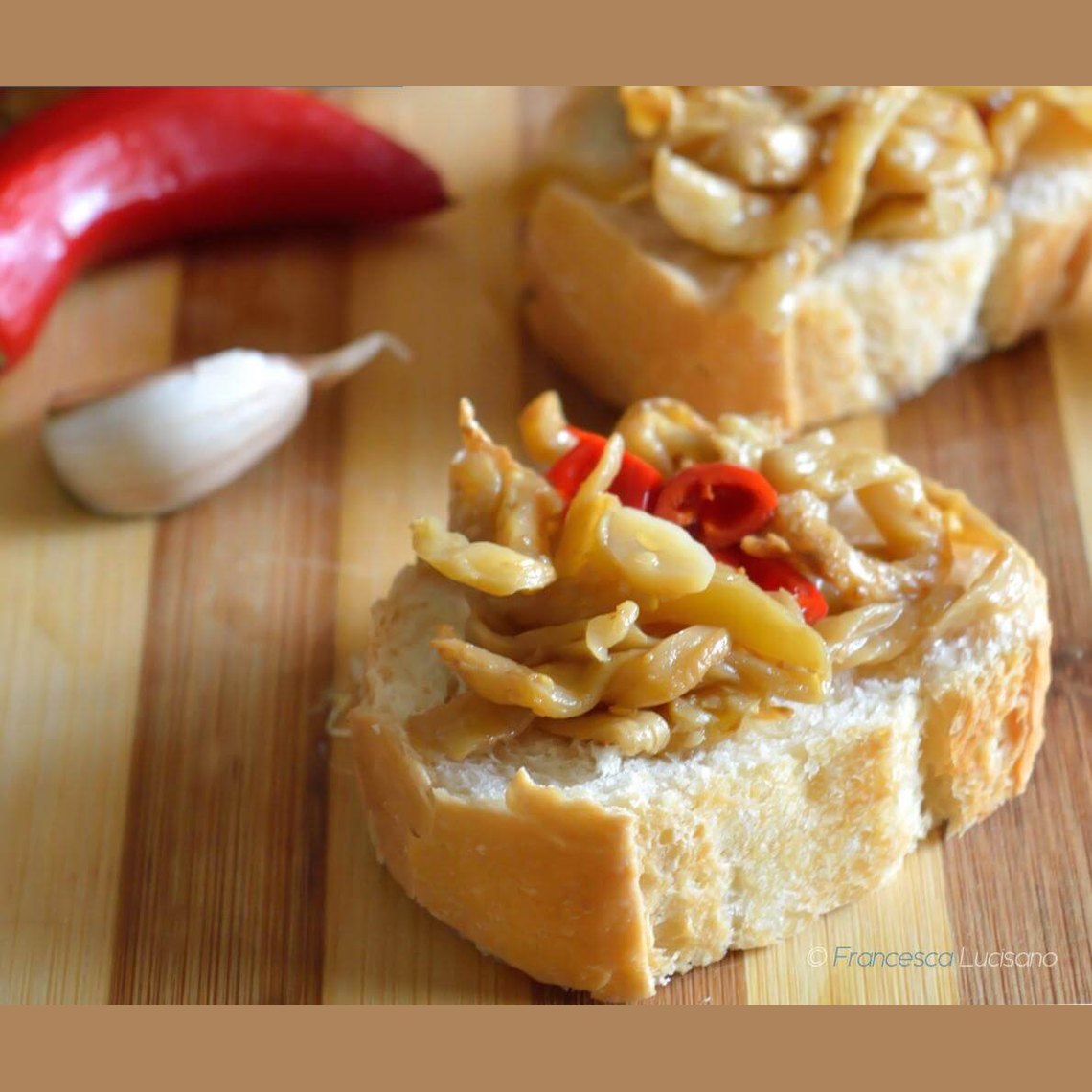 Delicious Melanzane a Filetti on bread, garnished with chili, garlic, showcasing traditional Calabrese flavors.