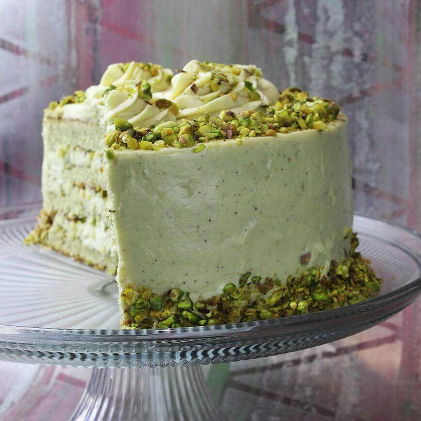 Crema spalmabile dolce di Pistacchio cake topped with pistachios and cream, perfect for desserts and celebrations.