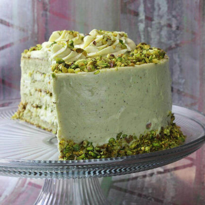 Crema spalmabile dolce di Pistacchio cake topped with pistachios and cream, perfect for desserts and celebrations.