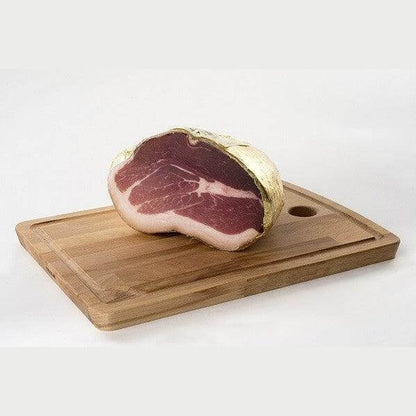 Culaccia di Modena displayed on a wooden cutting board, showcasing its rich marbling and unique shape.