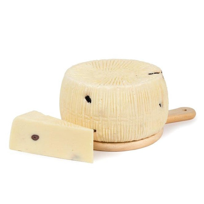 Primo sale con Olive Nere formaggio siciliano su tagliere con pezzo a lato.