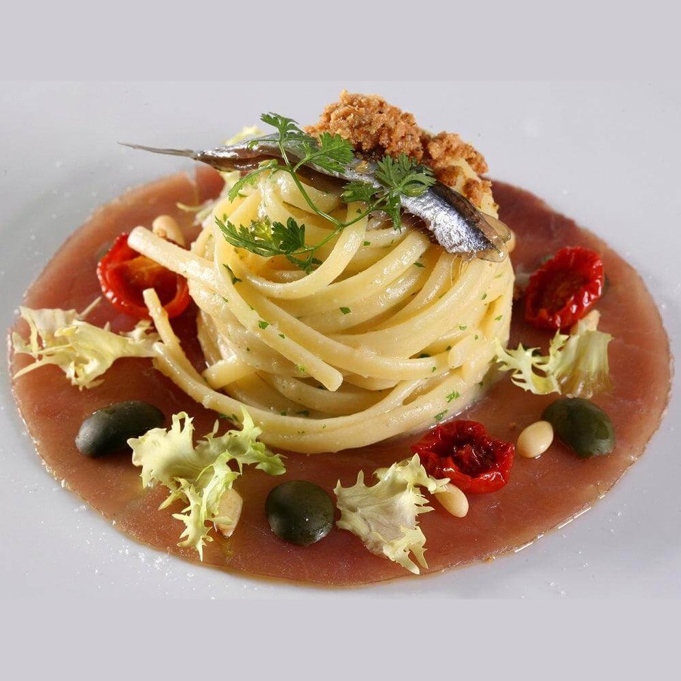 Delicious spaghetti topped with anchovies, sun-dried tomatoes, and herbs, perfect for Colatura di Alici.