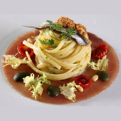 Delicious spaghetti topped with anchovies, sun-dried tomatoes, and herbs, perfect for Colatura di Alici.